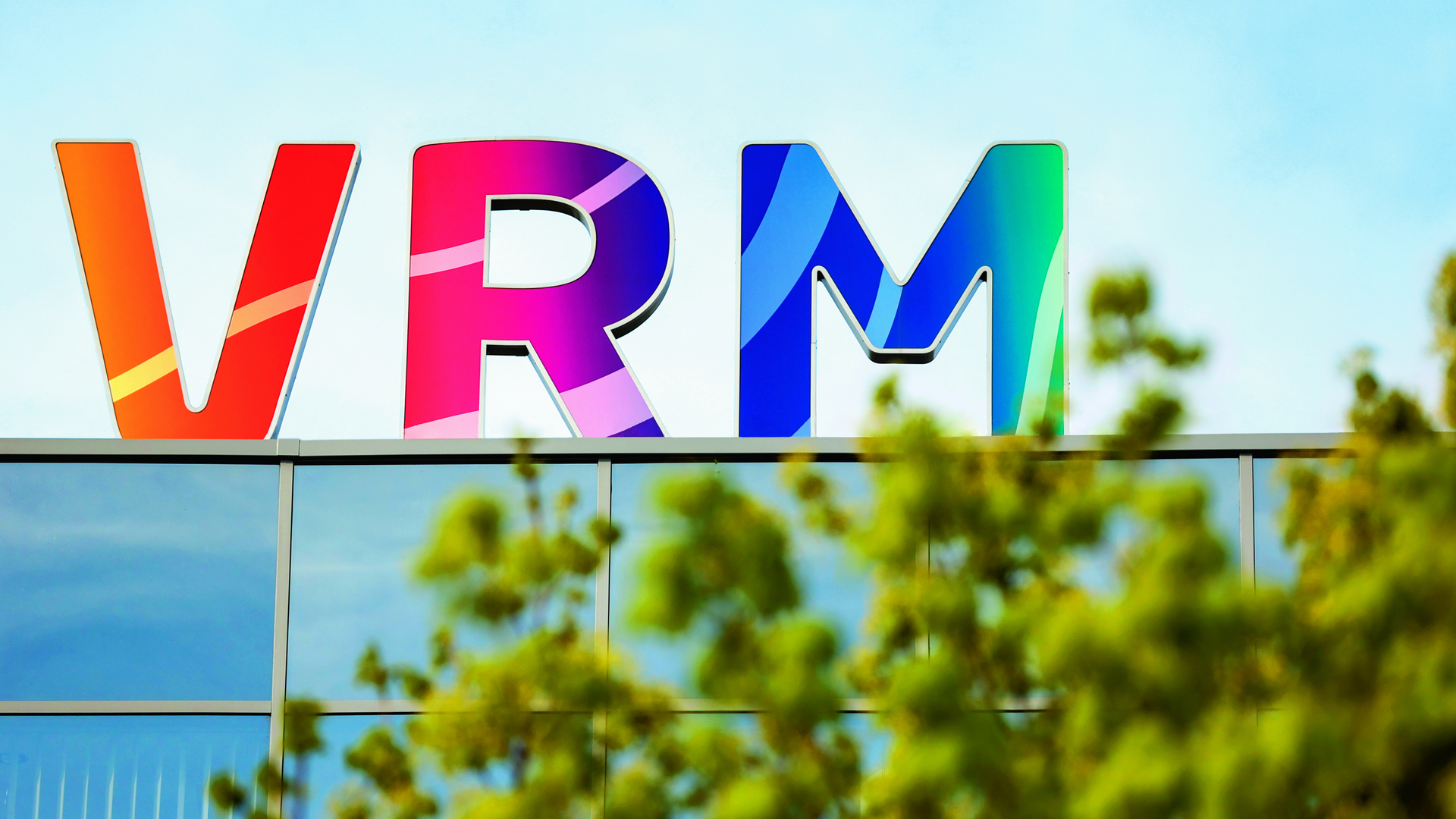 Das Logo der VRM in leuchtenden Farben mit einer Baumkrone im Vordergrund.